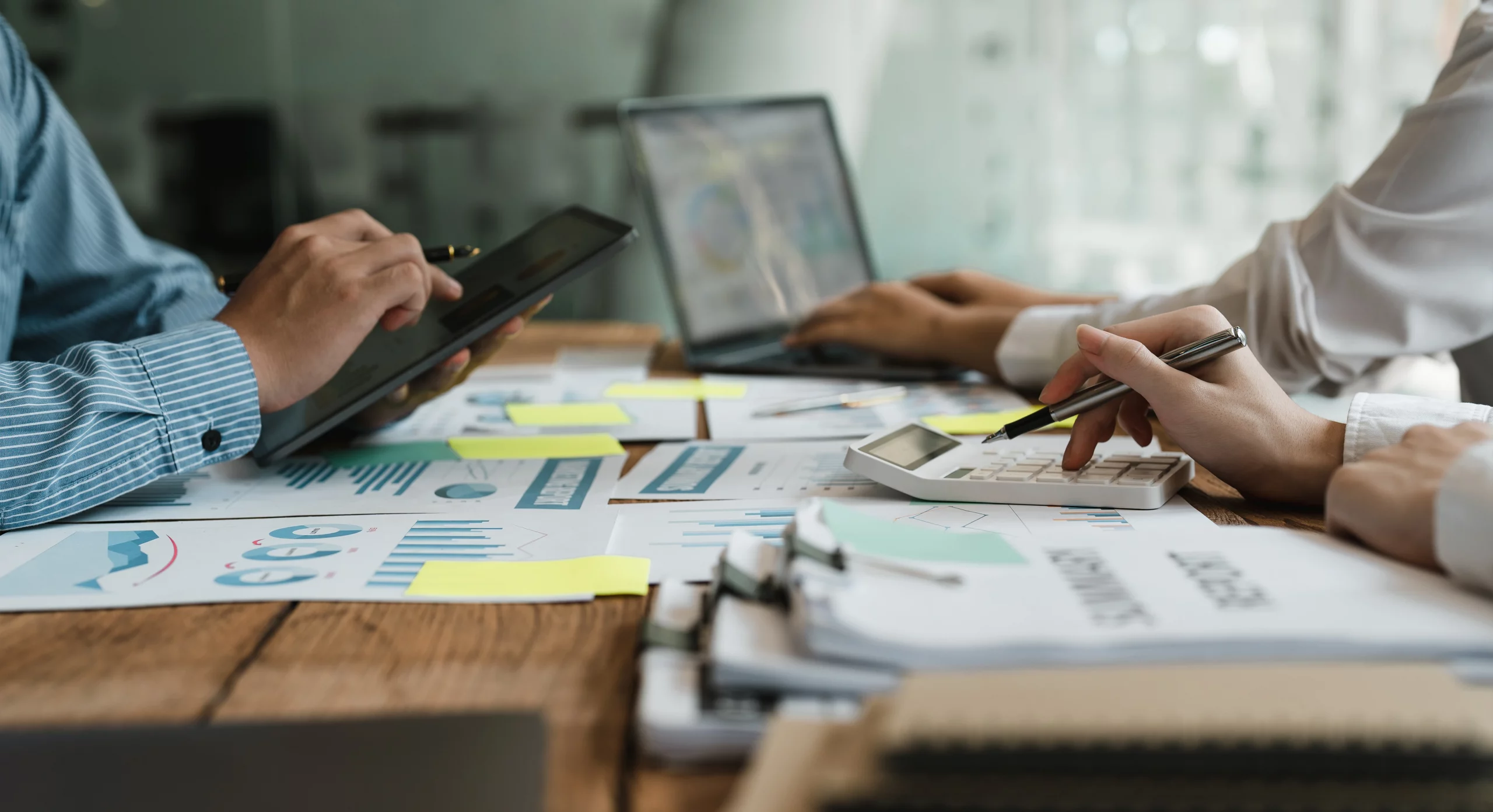 Aktuelles Team arbeitet bei UBBZ Steuerkanzlei mit Tablet, Diagrammen und Taschenrechner an Steuerunterlagen.