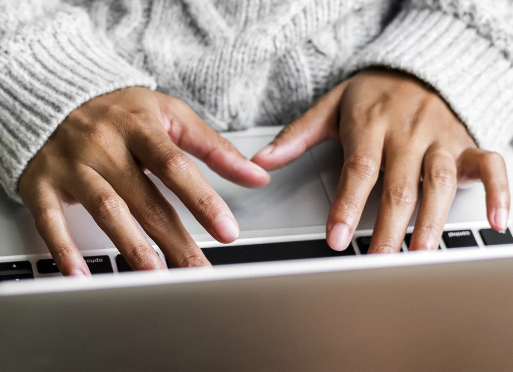 Hände tippen auf einer Laptop Tastatur